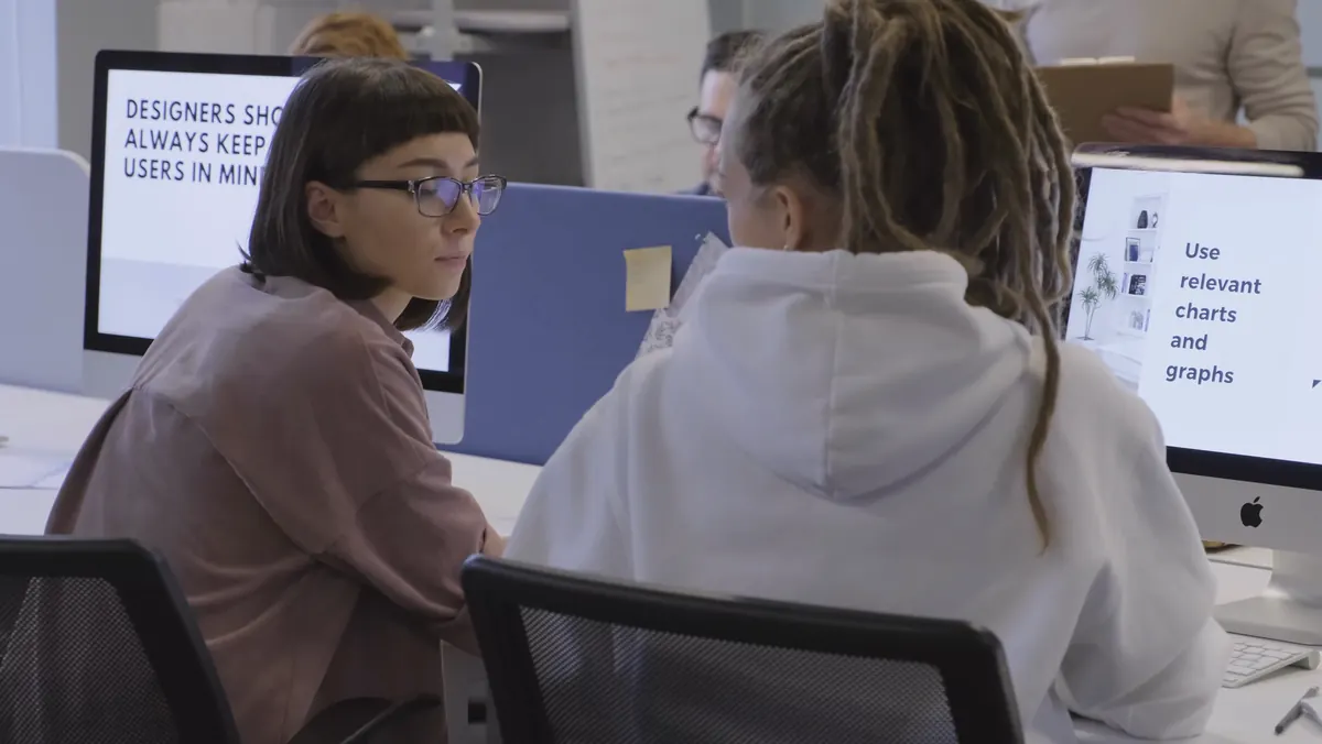 Colleagues reviewing slides on a desktop computer